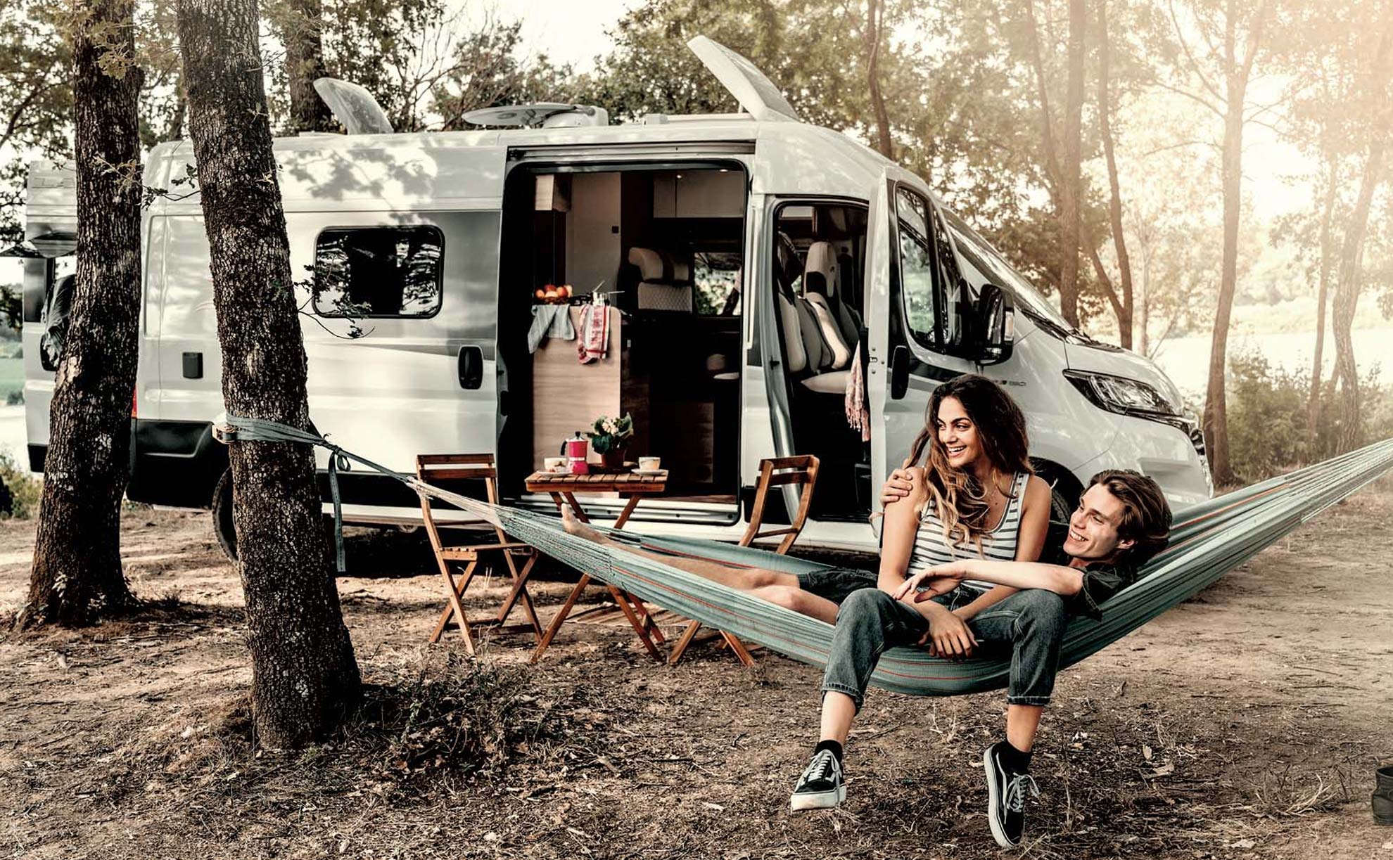 Camper mit einem Pärchen auf einem Campingplatz