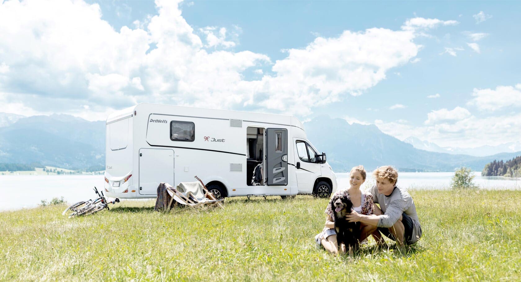 Teilintegriertes Wohnmobil auf der Wiese mit Personen und einem Hund