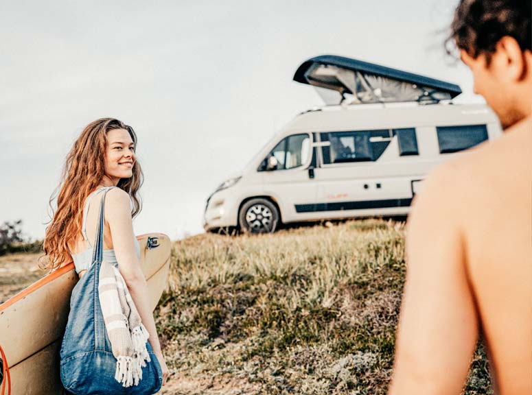 Zwei Personen vor einem Camper