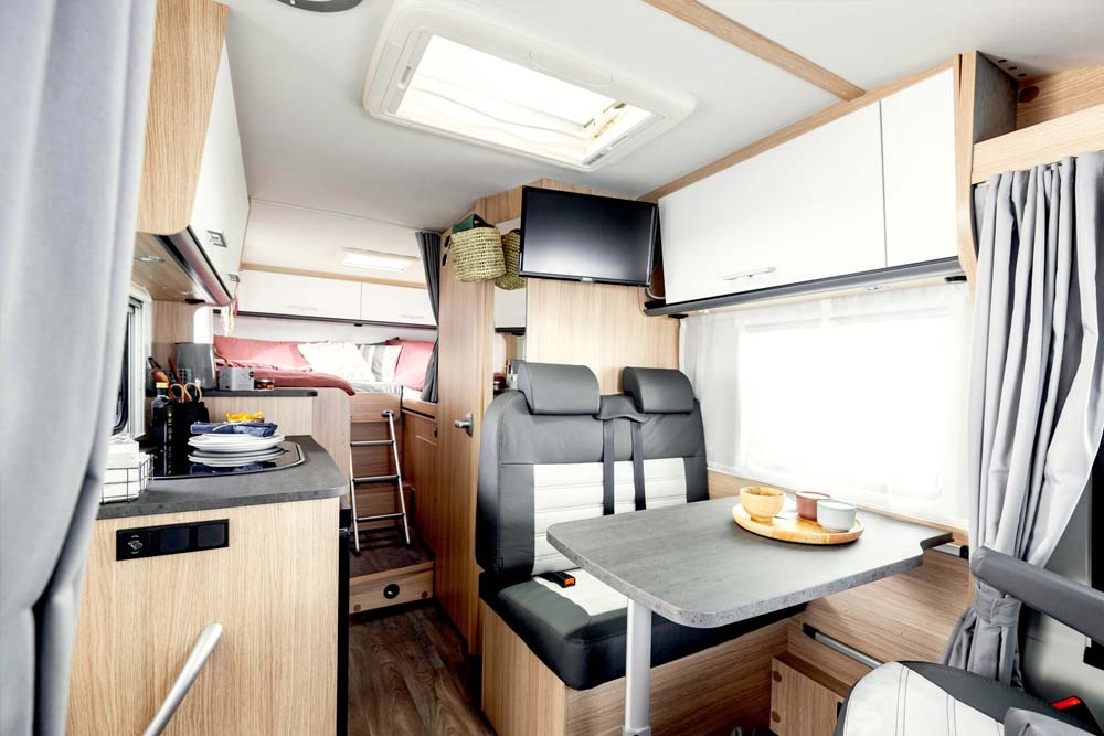 Übersicht der Wohnbereiche Sitzecke, Küche und Schlafzimmer des teilintegrierten Wohnmobil Freedom von Roadfans
