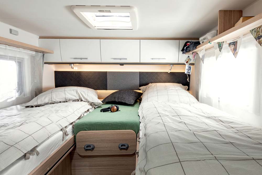 Großes gemütliches Bett mit den Bettenmasse 2x 201 x 87 cm mit Bettbezug von vollintegrierten Wohnmobil Independence von Roadfans.