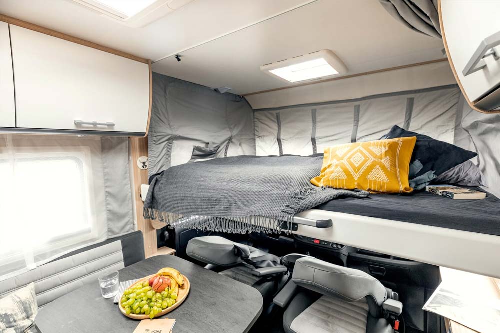 Großes und gemütliches Hubbett mit gelben Kissen und grauen Bettbezug als zusätzlicher Schlafplatz für 2 Personen mit den Bettenmassen 193 x 150 cm .