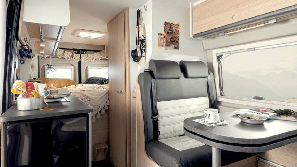 Die Wohnbereiche Küche, Sitzecke und Bett eingerichtet im Wohnmobil Kastenwagen Journey