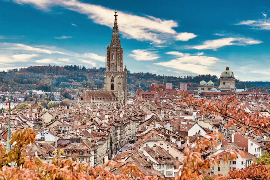 Historische Bauten in Bern betrachten mit Blich auf die Berge.