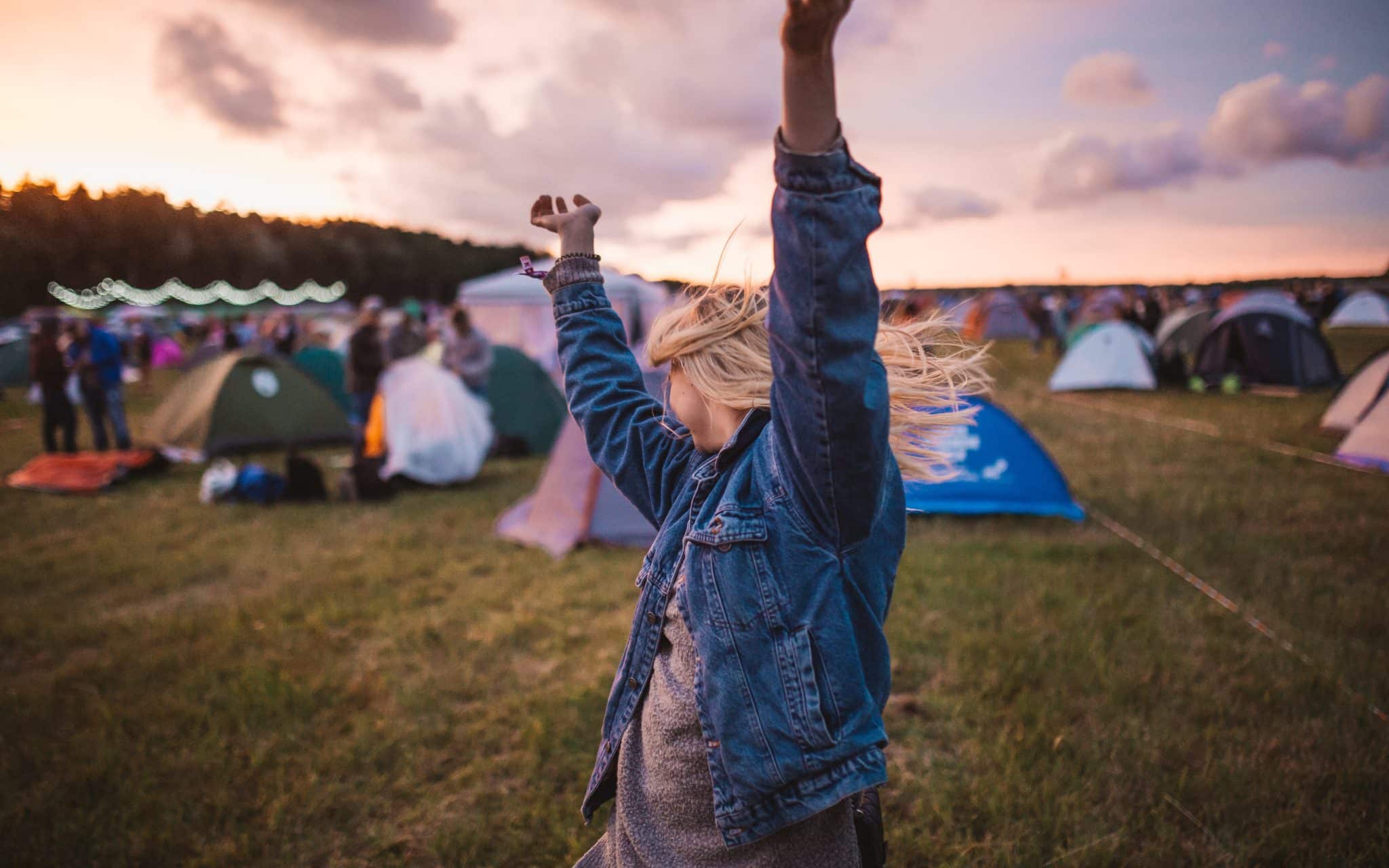 Frau tanzt auf einem Campingplatz