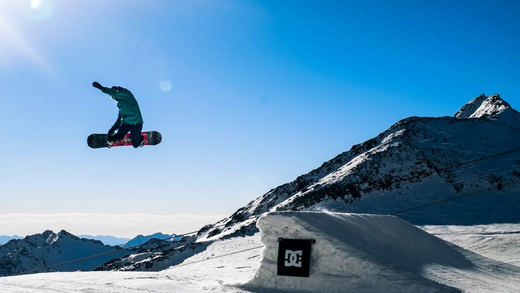 Ein Snowboarder springt über eine Rampe