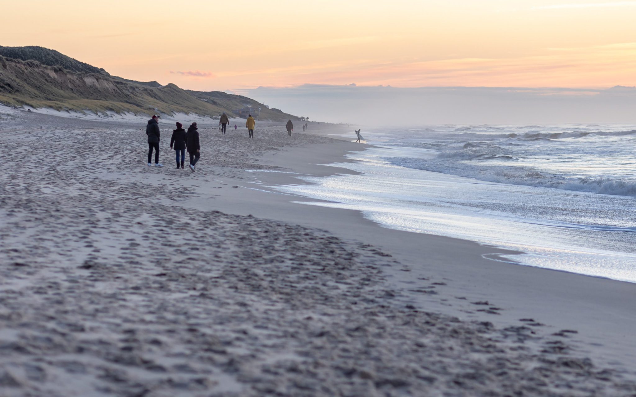 Wintercamping Nordsee - Menschen gehen am Nordsee Strand entlang