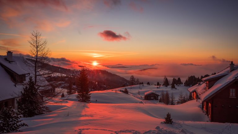 verschneites Bergdorf bei Sonnenuntergang
