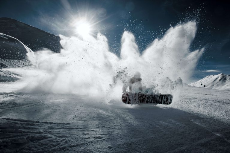 Snowboarder schleudert beim bremsen Schnee auf