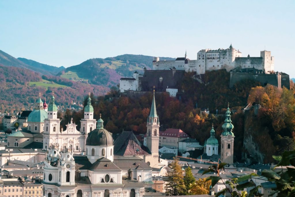 Stadt Salzburg mit der Festung Hohensalzburg auf einem Berg im Hintergrund. 