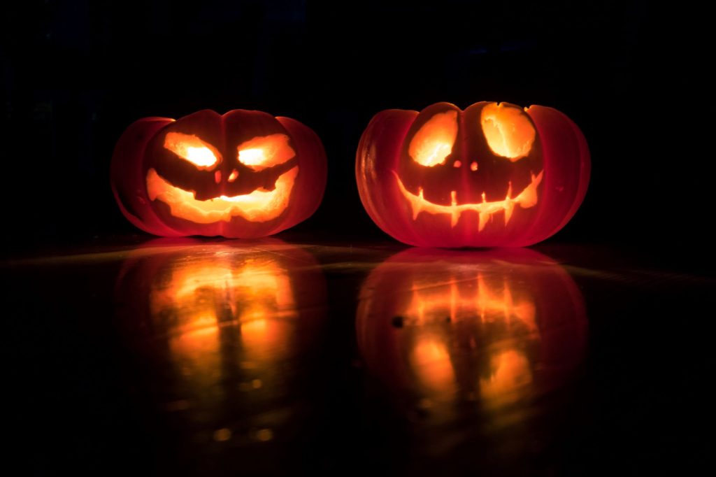 Halloween Wochenende - Blick auf zwei geschnitzte Kürbisse, die am leuchten sind.