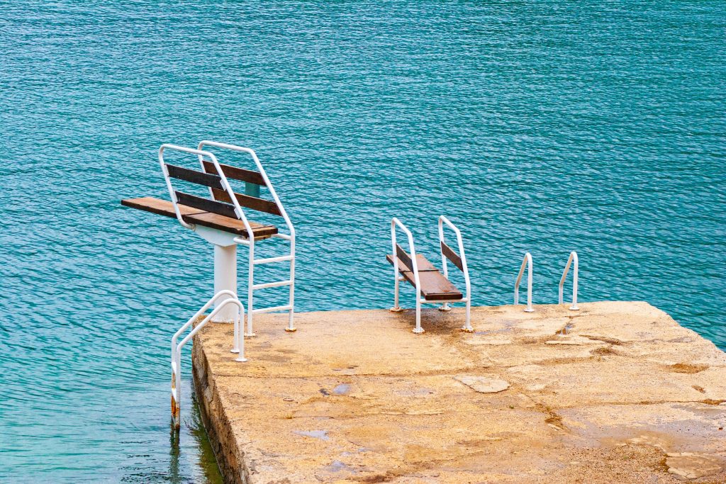 Glamping Kroatien - Eine Schwimminsel mit Sprungbrettern am türkisen Wasser 