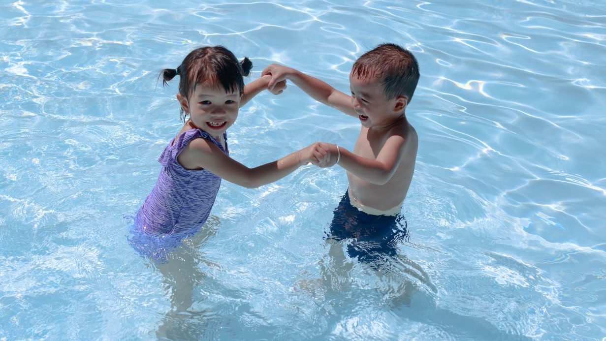 Zwei Kinder planschen im Wasser