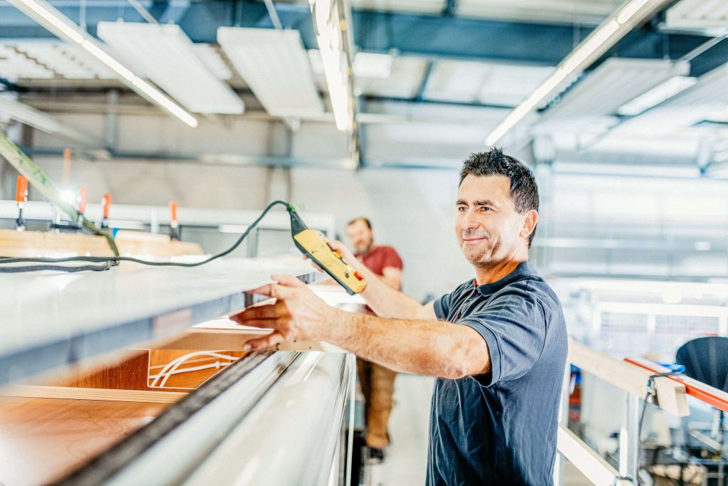 Wohnmobil Solaranlage prÃ¼fen - Blick auf einen Arbeiter in der ROADfans-Werkstatt.