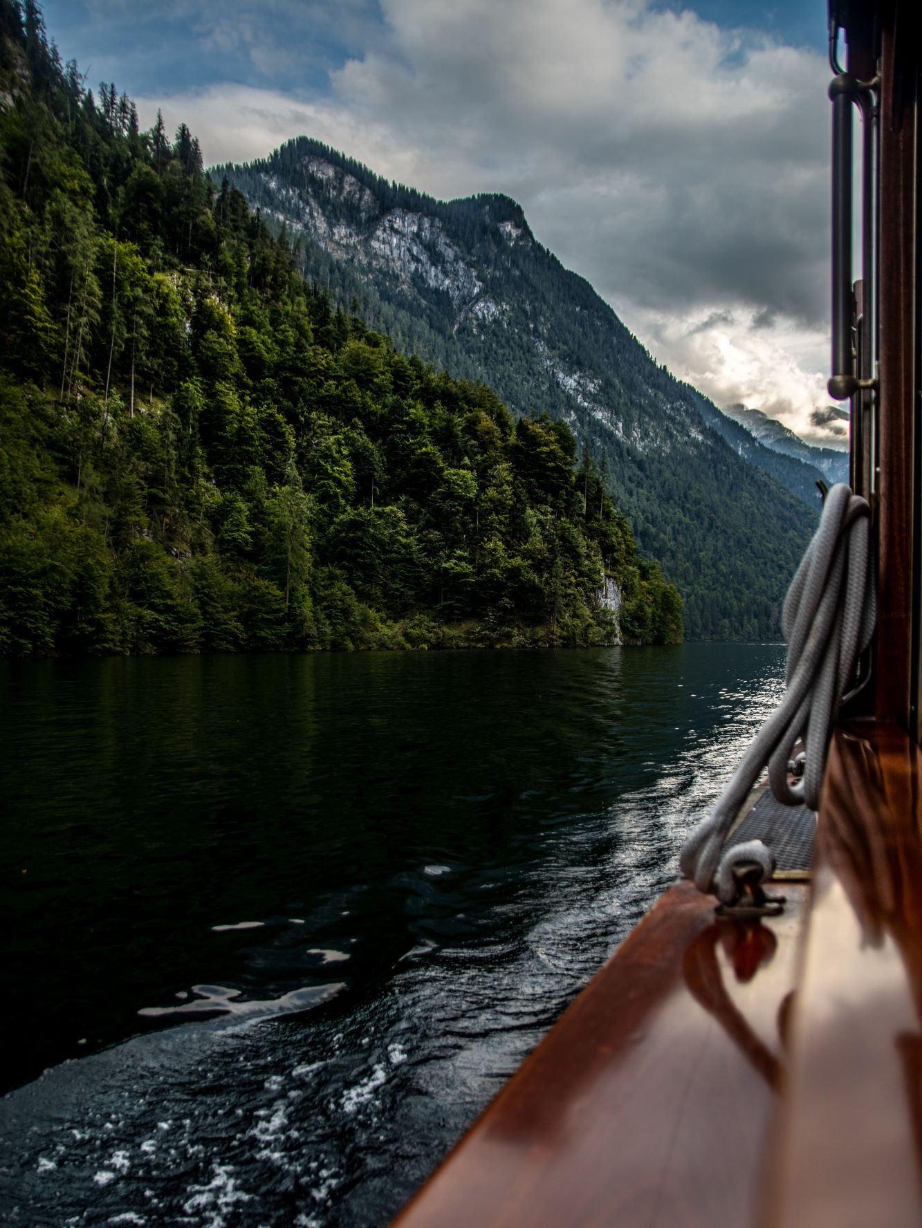 Blick aus einem Boot auf den Königssee. Im Hintergrund befinden sich Berge