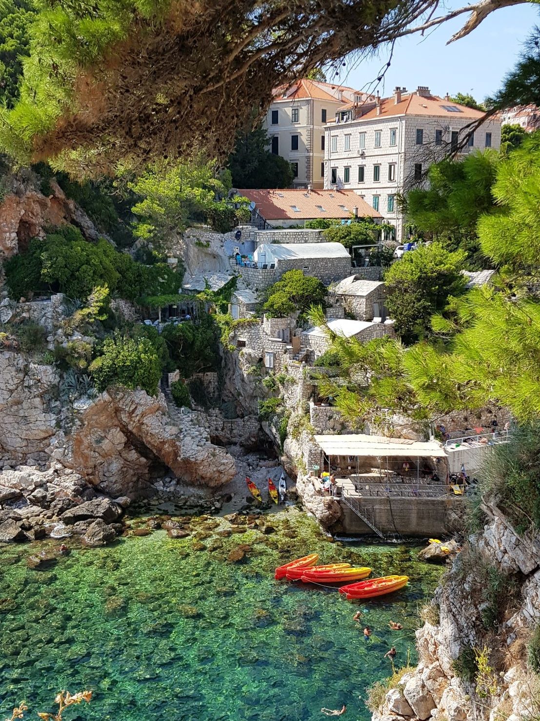 Küste in Kroatien. Häuser, Nadelbäume und Boote sind zu erkennen